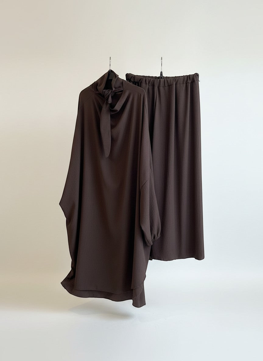 Nesthetics Jazz Jilbab in Schokoladenbraun mit Schleife am Kragen und elastischem Bund. Elegante und bescheidene Kleidung aus Jazz-Material.