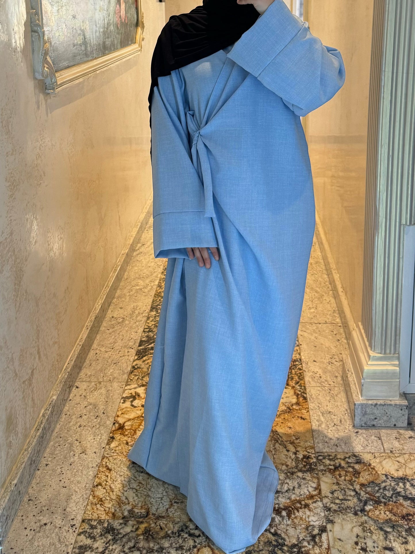 Nesthetics light blue linen-look wrap abaya with wide sleeves and a round neckline, made in France.