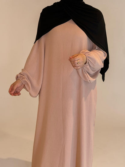 Nesthetics Abaya Malika aus Jazz Stoff in zartem Rosa mit Ballonärmeln und schwarzem Hijab.