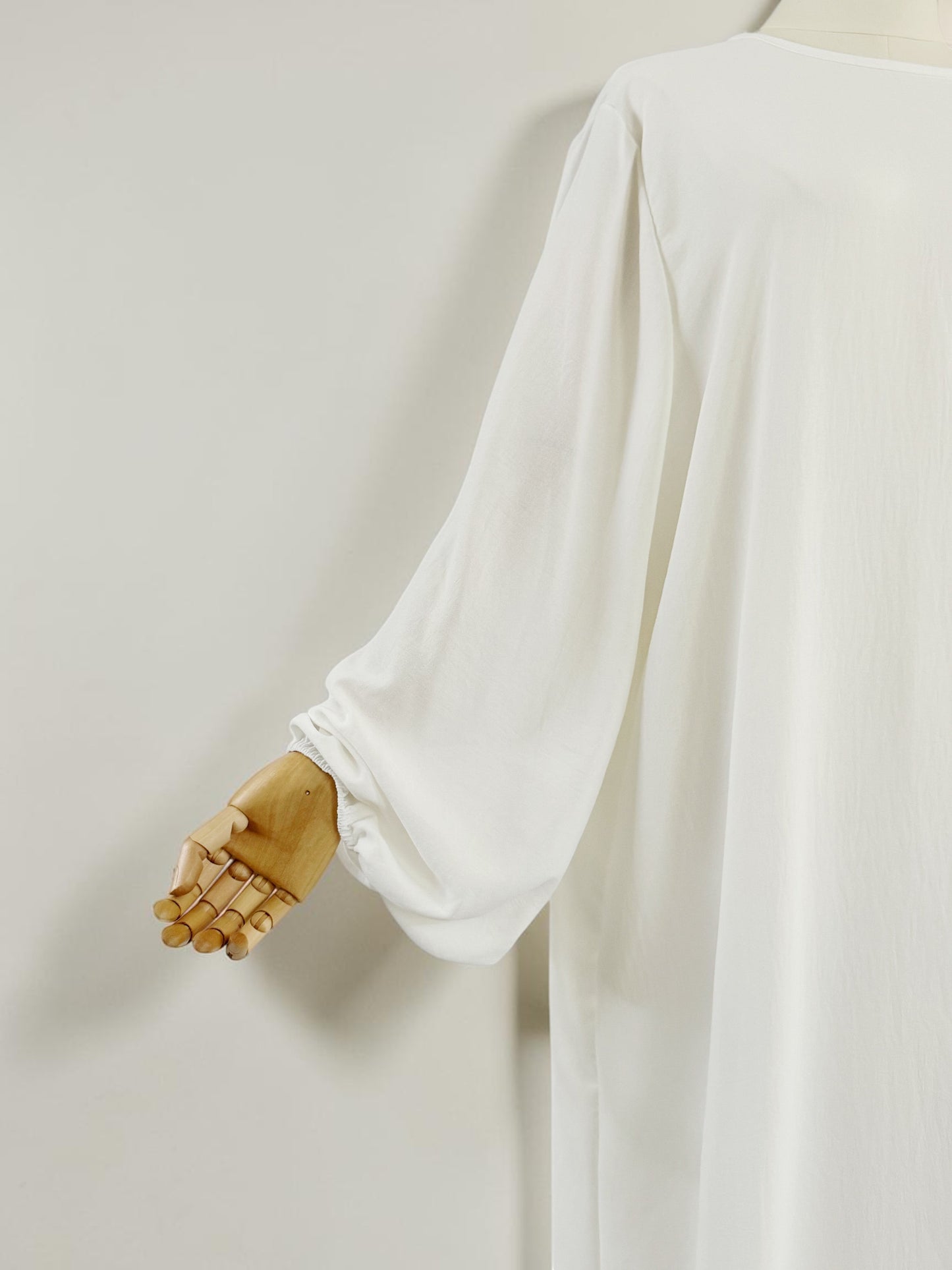 Nesthetics Abaya Malika in Weiß aus Jazz Stoff mit Ballonärmeln und geradem Schnitt.