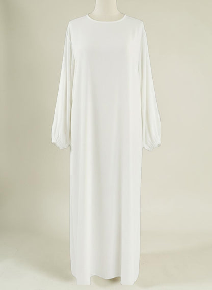 Nesthetics Abaya Malika, fließendes weißes Kleid aus Stoff mit Rundhalsausschnitt und gerafften Ärmelbündchen.