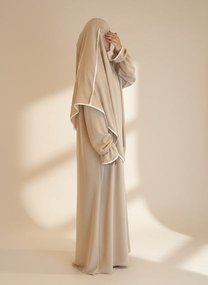 Beiges Nesthetics Abaya und Khimar Set aus Jazz Stoff mit weißen Details und Volant-Ärmeln in Seitenansicht
