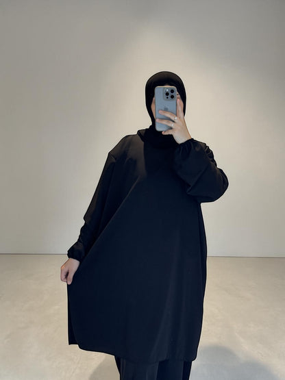 Nesthetics black 2-in-1 abaya made of Medina silk, featuring a long tunic and an underdress. Standard size, 140cm length.