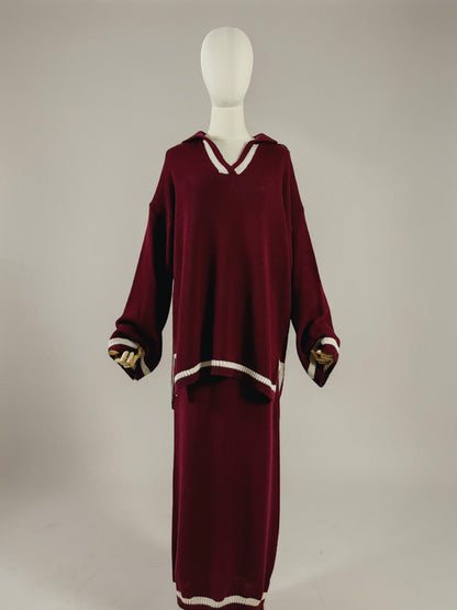 Nesthetics burgundy knit sweater with V-neck and white trim, paired with a matching midi skirt. White striped cuffs and hem.