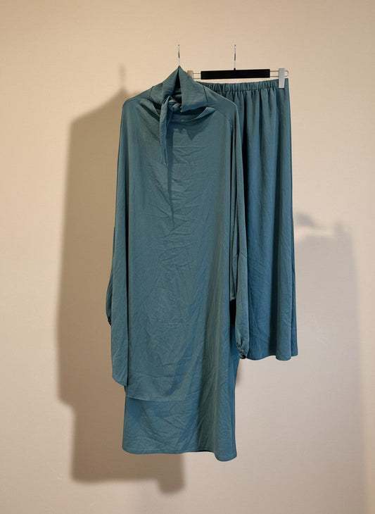 Nesthetics Jazz Jilbab in Aquamarin mit elastischen Ärmelbündchen und passendem Rock auf einem Kleiderbügel