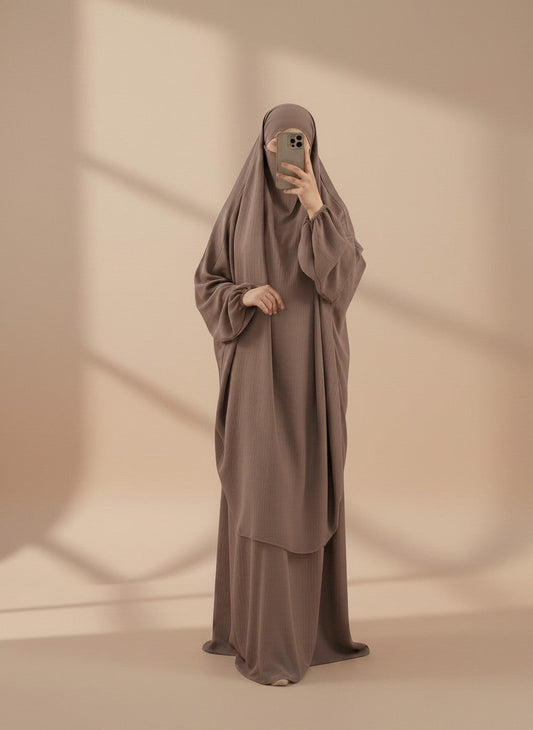 Nesthetics Jazz Jilbab in Taupe mit elastischen Ärmelbündchen und passendem Rock, getragen von einer Frau im Spiegel.
