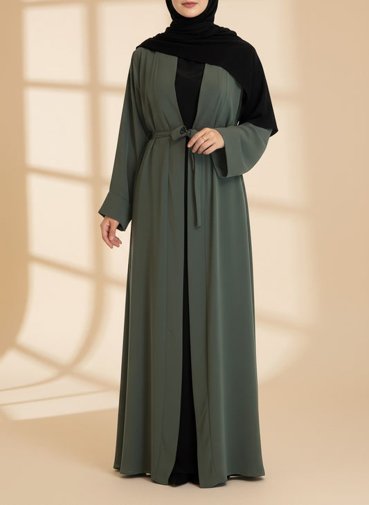 Nesthetics Kimono Abaya Almas in Khaki aus Medina-Seide mit Bindegürtel, getragen über einem schwarzen Unterkleid.