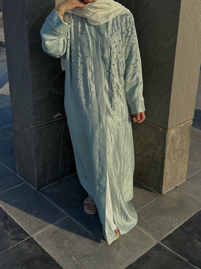 Nesthetics light blue flowing abaya with intricate bead and stone embroidery on the chest and sleeves. Long sleeves, modest design, ideal for special occasions.