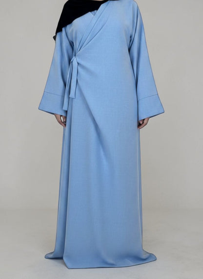 Nesthetics light blue linen-look wrap abaya with wide sleeves and round neck, made in France.