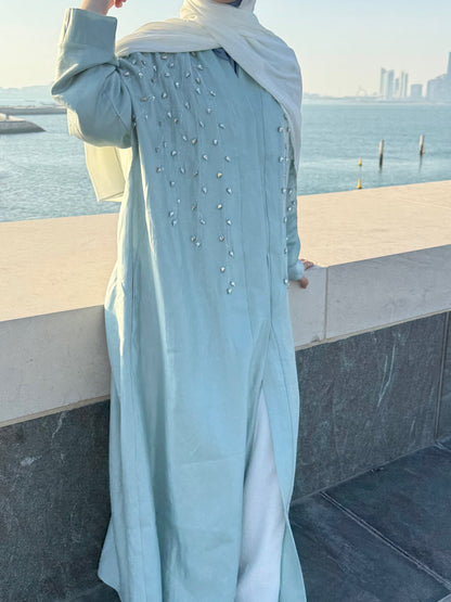 Nesthetics Royal Abaya in seabreeze blue, flowing fabric with crystal embellishments and side slits. Elegant modest wear.